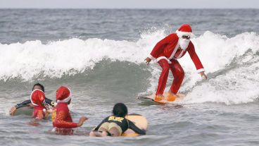 Papá Noel surfeando en una playa del Caribe.