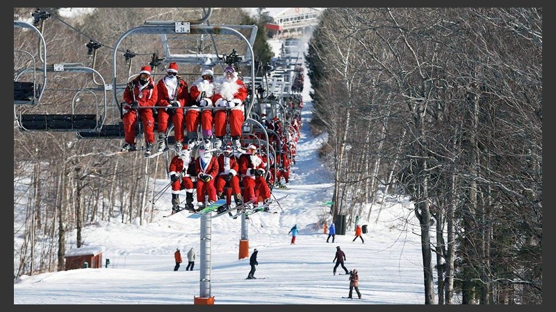 Un grupo de Santas en una aerosilla preparados para esquiar.