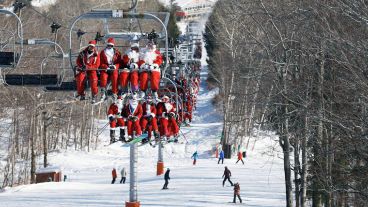 Un grupo de Santas en una aerosilla preparados para esquiar.