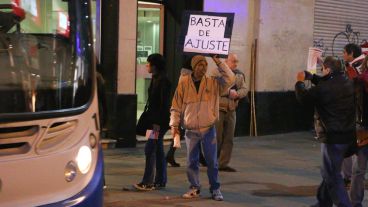 Un hombre muestra un cartel en plena peatonal Córdoba.