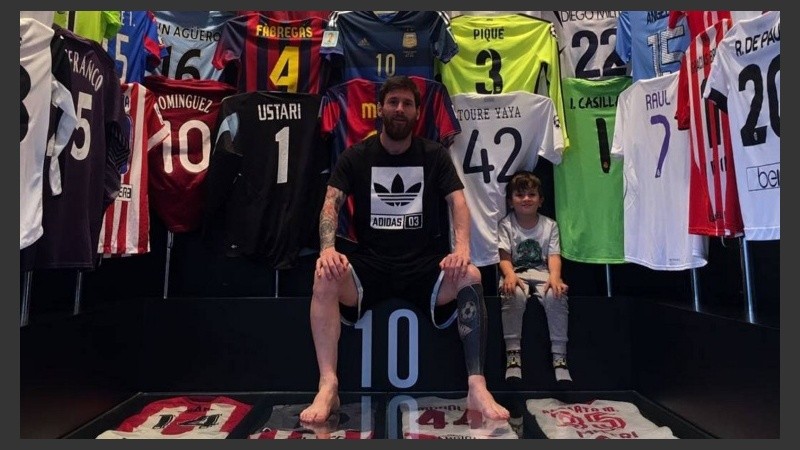 Messi con uno de sus hijos y sus camisetas. 