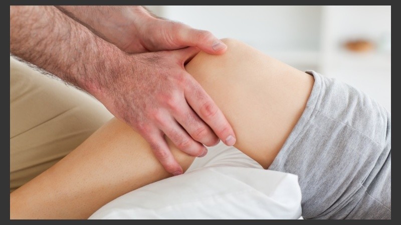 Man massaging a woman's knee in a room