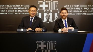 Messi, sonriente junto al presidente del Barsa Bartomeu.