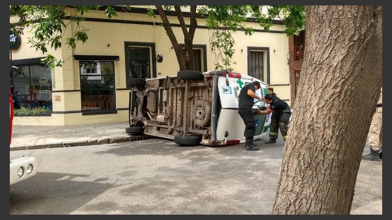 Bomberos tratando de abrir las puertas traseras de la ambulancia. 