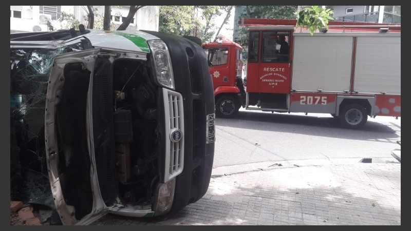 La ambulancia volcada en primer plano y el camión de bomberos detrás. 