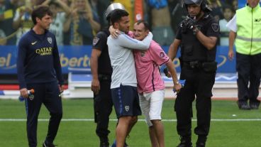 Un hincha saltó a la cancha y Tevez lo saludó.