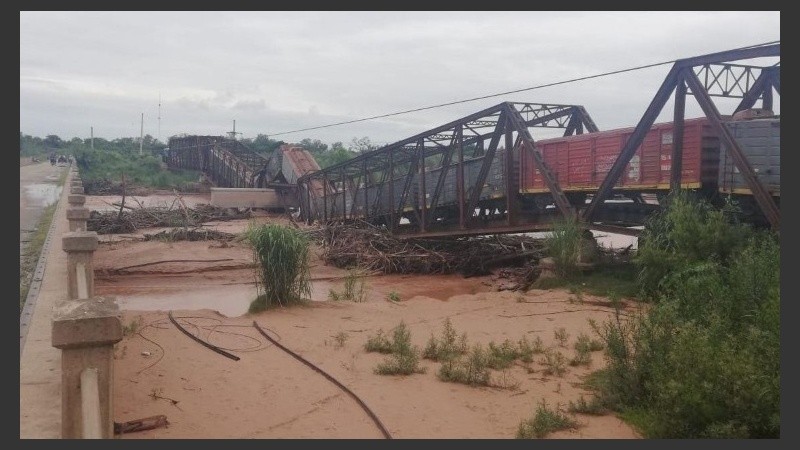 El tren sobre el puente caído y el río desbordado. 