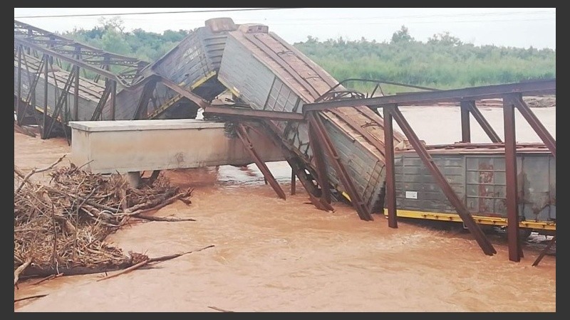 El tren sobre el puente caído y el río desbordado. 