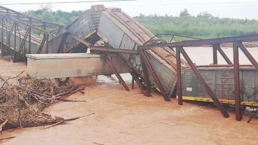 El tren sobre el puente caído y el río desbordado.