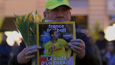 Un hombre muestra la portada de la revista France Football con la foto del futbolista argentino.