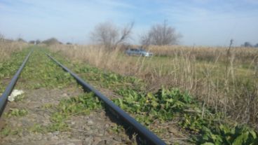 Las vías del ferrocarril al lado del auto que fue saqueado.