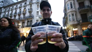 Un joven repartía vasos con caña a la gente que pasaba por el lugar.