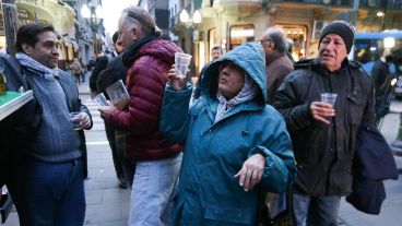 La gente que pasaba por Córdoba y Corrientes tomada un trago de caña de ruda.