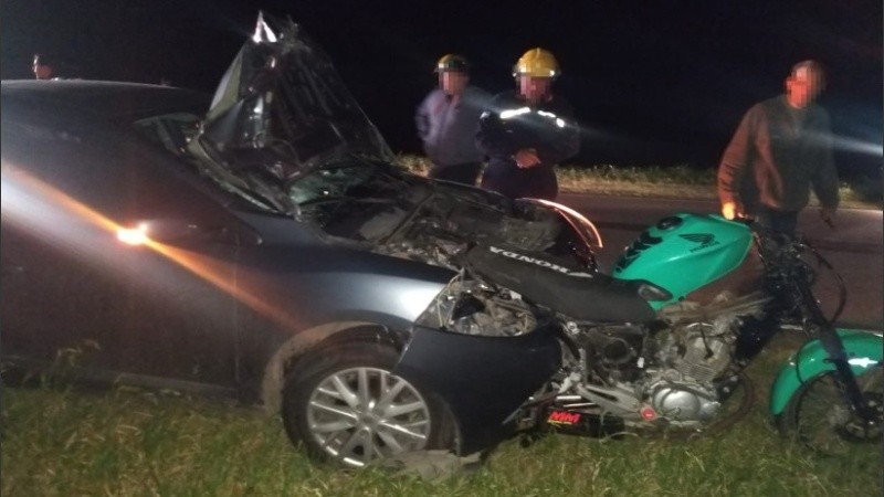 La moto quedó debajo del auto por la fuerza del impacto. 