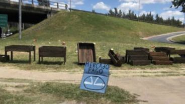 El cartel está puesto sobre la Panamericana y el hombre vende macetas.