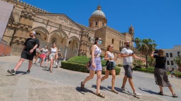 Turistas disfrutan de un día de sol frente a la Catedral de Palermo, Italia