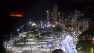 Una vista de la costa central y de fondo, el fuego de este domingo.