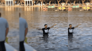 Con el agua a la altura de la cintura, el hombre festeja haber cumplido con su cometido.