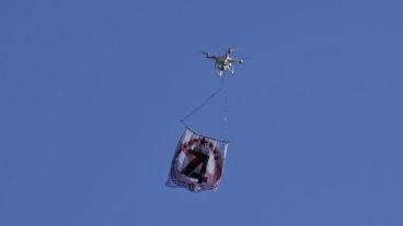 El dron con la bandera sobre el Gigante de Arroyito.