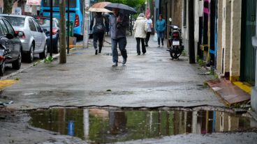 Rosarinos y rosarinas yendo a votar bajo el agua.