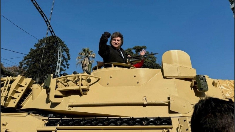 El presidente Javier Milei posa, con el puño en alto, desde un tanque del Ejército argentino.