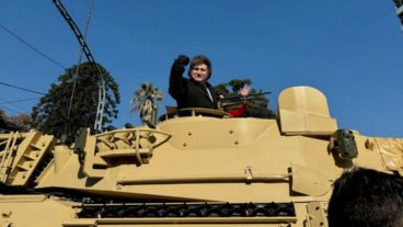 El presidente Javier Milei posa, con el puño en alto, desde un tanque del Ejército argentino.