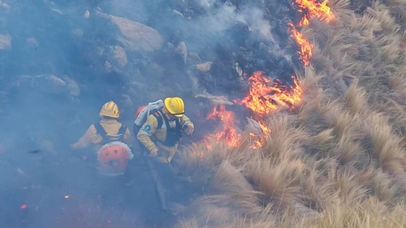 Brigadistas trabajan para contener el fuego en una zona de difícil acceso.