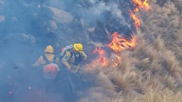 Brigadistas trabajan para contener el fuego en una zona de difícil acceso.