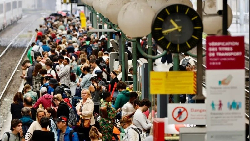 Pasajeros esperan en los andenes de una estación de tren de París.