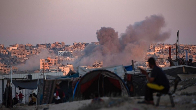 Un ataque aéreo israelí mientras los palestinos desplazados internos se sientan junto a sus tiendas de campaña en el sur de la Franja de Gaza.