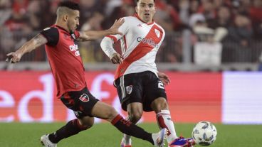 Cardozo y Acuña, que debutó en River, disputan una pelota en el Monumental.