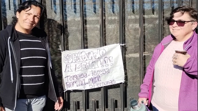 Mujeres encabezan una fila en el camping de zona sur junto a un cartel que indica cuántas personas son las que deben ingresar al predio.