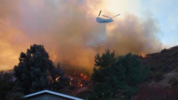 Un helicóptero arroja agua en medio del incendio de Palisades, el foco más activo de Los Ángeles.